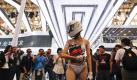 Sex sells: Eine Hostess verteilt auf der Automobilmesse in Peking im Bikini mit Helm und Handschuhen Prospekte. Foto: Diego Azubel Foto: dpa