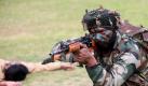 Gut gerüstet für alle Lebenslagen präsentiert sich dieser indische Soldat bei einer Übung in Neu Delhi. Das «Opfer» im Hintergrund stand gleich danach wieder auf. Foto: Harish Tyagi Foto: dpa