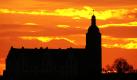 Hinter der Silhouette von Schloss Leitzkau in der Nähe von Magdeburg geht die Sonne auf und färbt den Morgenhimmel orangerot. Foto: dpa
