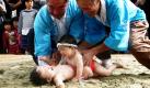 Die spinnen, die Japaner. Sumo gilt als Volkssport Nummer eins bei den Japanern. Dass allerdings bereits Babys zu dem Ringen antreten müssen, ist zumindest in unserem Breiten neu. Zugrunde liegt diesem Baby-Ringen der Glaube, die Kinder würden gesund aufwachsen, wenn sie sich erst im Dreck eines Sumo-Kampfplatzes gesuhlt haben.  Foto: dapd