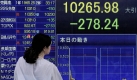 Eine Frau schaut auf eine elektronische Anzeigetafel des japanischen Nikkei-Indexes. Nach schweren Verlusten am Vortag hatten sich die Kurse in Japan am Vormittag noch immer nicht erholt. Foto: ap