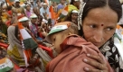 A Congress party supporter carries her child as she listens to President Sonia Gandhi, unseen, at an election rally in Allahabad, India, Sunday, April 19, 2009. India's national elections, which began Thursday will take place over five phases until May 13. (AP Photo/Rajesh Kumar Singh) Foto: ap