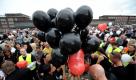 Teilnehmer eines Trauermarsches für die 21Opfer der Loveparade hielten vor dem Bahnhof in Duisburg schwarze Luftballons.
 Foto: ddp