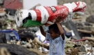 Das Bild der Verwüstung wird Amerikanisch-Samoa so schnell nicht los werden. Die Menschen klammern sich derweil an Rituale. Ein kleiner Junge rettet deshalb wohl eine Weihnachtsmannfigur. Foto: ap
