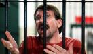 Der vermeintliche russische Waffenhändler Viktor Bout spricht aus seiner Zelle in einem Gericht in Bangkok mit Journalisten. Ein thailändisches Berufungsgericht verfügte die Auslieferung des Mannes, der auch Händler des Todes genannt wird an die USA. Damit kippte es eine vorherige Entscheidung eines niedrigeren Gerichts. Der 44-Jährige Bout ist seit März 2008 inhaftiert, als er bei einem Täuschungsmanöver durch US-Agenten gefasst wurde. Foto: dpa