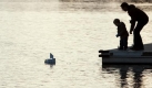 Als Silhouette erkennbar stehen Vater und Sohn am Sonntag am Aasee in Münster auf einem Steg und blicken auf ein kleines Papierboot. Freundlich mit vielen sonnigen Abschnitten und Temperaturen um 10 Grad Celsius zeigt sich das Wetter in weiten Teilen Nordrhein-Westfalens. Foto: dpa