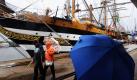 So hatten sich die Besucher der Sail 2010, die sich das italienische Vollschiff Amergio Vespucci anschauen ihren Ausflug nach Bremerhaven sicher nicht vorgestellt: Die Segelfeier fällt leider ins Wasser. Auch die Veranstalter dürften nicht glücklich sein mit der Situation, denn das schlechte Wetter bremst den Besucheransturm auf das Treffen der Großsegler in der Seestadt. Foto: dpa