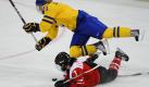 Huch, da war wer im Weg: Schwedens Eishockeyspielerin Jenni Asserholt (oben)  stürzt über die auf dem Eis liegende Darcia Leimgruber aus der Schweiz. Auch beim Frauen-Eishockey geht es augenscheinlich nicht gerade zimperlich zur Sache. Foto: dpa