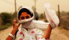 Indische Frauen schützen sich mit Kopftüchern gegen einen Sandsturm in der indischen Stadt Jammu. Foto: ap