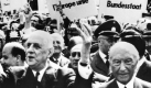 Gestenreich bedankt sich Charles de Gaulle (l) während seines Besuchs in Bonn im Mai 1962 bei den jubelnden Bürgern, die Plakate mit der Aufschrift 'Wir wollen den europäischen Bundesstaat' und 'Vive lÂEurope unie' hochhalten. Begleitet wird der französische Staatspräsident von Bundeskanzler Konrad Adenauer (r). Freundschaft gelobten sich vor 35 Jahren die einstigen Erzfeinde Deutschland und Frankreich im Elysee-Vertrag. dpa (zu dpa-Korr 'In 35 Jahren wuchs enges deutsch-französisches Beziehungsgeflecht' vom 19.01.1998) nur sw  Foto: dpa