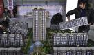 Arbeiter installieren ein Modell eines Wohnparks auf einer Messe in Shanghai. Das Projekt soll in der nordostchinesischen Liaoning Province realisiert werden. Foto: ap