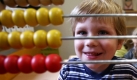 Der kleine Noa Sengmüller schaut in dem Kindergarten Klax in Berlin durch einen Rechenschieber. Der Berliner Senat will heute über die Finanzierung der geplanten zusätzlichen 1800 Kita-Erzieherinnen beraten. Foto: ddp