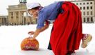 Mit Mühe rollt Hollands Käse-Lady 'Frau Antje' am Donnerstag (14.01.2010) vor dem Brandenburger Tor in Berlin ihren Käse durch den tiefen Schnee zur Grünen Woche. Unter dem Motto 'Smaak' (Geschmack) präsentiert Holland Qualitätsprodukte für Genießer. Die 75. Internationale Grüne Woche in den Hallen unter dem Funkturm, mit 1600 Ausstellern aus 56 Ländern, öffnet für die Besucher vom 15. - 24. Januar ihre Tore. Foto: Wolfgang Kumm dpa/lbn +++(c) dpa - Bildfunk+++  Foto: dpa