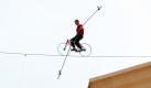 Nik Wallenda fährt mit seinem Rad über ein Drahtseil, das fast 80 Meter über der Erde zwischen zwei Häusern in Nassau auf den Bahamas gespannt ist. Er gehört zu einer berühmten Zirkusfamilie und fuhr sicher die 31 Meter auf dem Drahtseil - ohne Sicherheitsnetz. Damit brach er seinen eigenen Weltrekord, der ihm 2008 einen Eintrag ins Guiness Buch der Rekorde einbrachte. Foto: ap