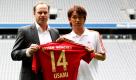 Bayern Münchens Neuzugang Takashi Usami (rechts) mit Manager Christian Nerlinger und seinem Trikot mit der Nummer 14 in der Allianz Arena in München. Der 19 Jahre alte Japaner kommt auf Leihbasis von Gamba Osaka (J-League) und ist als Ersatz für die Flügelspieler Arjen Robben und Franck Ribéry eingeplant. Foto: dapd