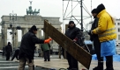 Arbeiter verlegen in Berlin am Brandenburger Tor während der Aufbauarbeiten für das Einheitsfest Holzbohlen. Das 20. Jubiläum des Falls der Mauer wird am Montag mit einem großen Fest in Berlin gefeiert. Foto: ddp