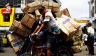 Ein Mann transportiert auf seinem etwas überladenen dreirädrigen Rad Handelsgüter durch Manila, Philippinen. Foto: dapd