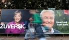 Passanten hasten in Hamburg an großflächigen Wahlplakaten mit Kanzlerin Merkel (CDU) und dem SPD-Spitzenkandidaten Steinmeier vorbei. Foto: dpa