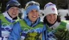 Charlotte Kalla (Mitte), Kristina Smigun-Vaehi (links) und Marit Bjoergen posieren gemeinsam bei der Flower Ceremony. Eine Schwedin gewinnt damit das Auftaktrennen der Langläuferinnen. Foto: dpa