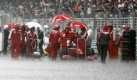 Auch Rot steht im Regen:Ferrari-Mechaniker haben viel zu tun und werden ordentlich nass. Foto: dpa