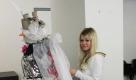 Praktikantin Lea Dzionsko tackert und klebt auf ein altes Top. Das Gürtelband besteht aus Bläschenfolie, Geschenkband und Papprollen. Foto: Maria Schmidt Dzionsko/ Freie Akademie Köln