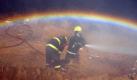 Chilenische Feuerwehrleute löschen einen Häuserbrand - und lassen unbeabsichtigt einen Regenbogen entstehen. Foto: Ariel Marinkovic Foto: dpa