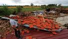Ein Unwetter hat in Niederbayern am Mittwochabend zu Hochbetrieb bei Polizei und Feuerwehr geführt. Während orkanartiger Sturmböen bei Starkregen gingen bei der Einsatzzentrale 600 Notrufe ein. Straßen wurden überschwemmt und Keller standen unter Wasser. Auf dem Foto steht ein Mann vor einem völlig zerstörtem Stall. Foto: dpa