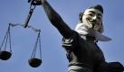 Demonstranten haben in Frankfurt/Main der Justitia auf dem Römerberg eine Guy Fawkes-Maske aufgesetzt. Foto: Marius Becker Foto: dpa