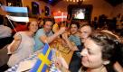 Touristen winken im Augustiner-Keller in München beim Public Viewing zum Eurovision Song Contest (ESC) 2011 mit Faehnchen der Laender Estland (links), Dänemark (mitte) und Schweden (unten). Foto: dapd