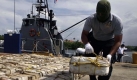 A police officer places packages containing cocaine on the floor at the port of Colon, some 80 km north of Panama City, Sunday, Sept. 20, 2009. Agents from Panama's National Sea and Air Service, SENAN, U.S. Coast Guard officers and Colombia's Coast Guard officers, seized about 4,818 kg of cocaine and detained three Panamanians, two Venezuelans and one Peruvian during a joint operation in international waters. (AP Photo/Arnulfo Franco) Foto: ap
