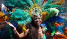 Ein Hauch von Rio in Berlin: Eine mit Federschmuck verkleidete Teilnehmerin des Karnevals der Kulturen posiert für die Kamera. Mit dem traditionellen Straßenumzug hat der 16. Karneval der Kulturen begonnen. Insgesamt 95 bunt kostümierte Gruppen mit 4.700 Akteuren aus 70 Nationen wollen bis zum Abend vom Hermannplatz zur Yorckstrasse ziehen. Der Umzug bildet den Höhepunkt des viertägigen Strassenfests. Foto: dapd