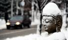 Im schweswig-holsteinischen Itzehoe trägt eine Buddha-Statue eine Mütze aus Schnee. Der erneute Schneefall vom Wochenende sorgt im Norden für extreme Verkehrsverhältnisse.  Foto: dpa