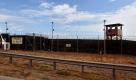 ARCHIV - Auf dem vom US-Militär herausgebenen Foto sind ein Wachturm und ein Tor des Gefangenenlagers Guantanamo in Guantanamo Bay auf Kuba zu sehen (Archivfoto vom 20.01.2009). Es ist Barack Obamas heiligstes Versprechen. Keine 24 Stunden hat er nach seiner Amtsübernahme gezögert, um die Schließung Guantànamos offiziell anzuordnen. Innerhalb eines Jahres sollte der Schandfleck der Bush-Ära beseitigt sein. Nicht nur die sogenannten Gutmenschen klatschten Beifall - das US-Gefangenenlager auf Kuba gilt weltweit als hässliches Symbol für Missachtung der Menschenrechte. Doch das vereitelte Flugzeug-Attentat des Nigerianers Abdulmutallab könnte die Schließung in Frage stellen. EPA/BRENNAN LINSLEY / POOL EDS: PHOTO HAS BEEN REVIEWED BY US MILITARY OFFICIALS (zu dpa 0293) +++(c) dpa - Bildfunk+++ Foto: dpa
