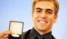 Philipp Lahm präsentiert anlässlich einer Ehrung im Bayerischen Umwelt- und Gesundheitsministerium seine Gesundheitsmedaille. Der Fußballer wurde damit für sein Engagement als Botschafter des alljährlichen Welt-Aids-Tages ausgezeichnet. Foto: ap