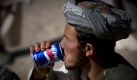 Ein Afghane trinkt am Montag (19.10.09) in dem Dorf Caqal Qeslaq in den Bergen bei Faizabad in Afghanistan waehrend eines gemeinsamen Mittagessens mit Bundeswehrsoldaten eine Pepsi. Beim gemeinsamen Mittagessen im Freien konnten die Dorfbewohner mit den Soldaten ueber aktuelle Probleme sprechen. Das Essen hatten die Soldaten vom Markt in Faizabad mitgebracht. Ueber 4000 Soldaten der Bundeswehr sind in der NATO gefuehrten Schutztruppe ISAF in Afghanistan im Einsatz. Foto: Michael Kappeler/ ddp Foto: ddp
