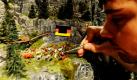 Ein Mitarbeiter des Miniatur Wunderlandes baut in Hamburg mit einer Pinzette das private Public Viewing auf einer Alm. Für die Zeit der Fußball-WM gibt es auf der Anlage des Miniatur Wunderlandes auch echte Fans und Autokorsos zu entdecken. Foto: dpa