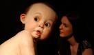Ein Mitarbeiter des Londoner Auktionshauses Christie's posiert neben der übergroßen Baby-Skulptur von Ron Mueck. Zur Auktion am 28. Juni 2011 wird ein Gebot von 680.000 bis 900.000  Euro erwartet. Foto: dapd