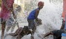 In Haitis Hauptstadt Port-au-Prince spielen Kinder an einer gebrochenen Wasserleitung. Foto: ap