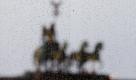 Die Quadriga auf dem Brandenburger Tor in Berlin bei Regenwetter durch eine Scheibe. Nach den schönen Osterfeiertagen zeigt sich das Wetter unbeständig. Lediglich der Norden und Nordwesten bleiben zunächst von Regen und Gewittern verschont, wie der Deutsche Wetterdienst (DWD) mitteilte. Ob die Regenmengen in den anderen Regionen ausreichten, um die Waldbrandgefahr einzudämmen, sei fraglich, hiess es. Am Wochenende (30.4.11/01.05.11) werde es zudem wieder sonnig und trocken. Foto: dapd