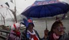 Regenkleidung, Schirm und bizarre Accessoires: Die Standart-Ausstattung britischer Queen-Anhänger beim Warten auf die Schiffsparade zum 60. Thronjubiläum der britischen Königin. Foto: Tal Cohen Foto: dpa