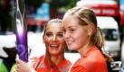 Die Besitzerin der olympischen Goldmedaille im Stabhochsprung Yelena Isinbayeva aus Russland gibt die olympische Flamme an Karin Biese, eine Studentin an der International School, in der Haupteinkaufsstraße in Singapur. Der Fackellauf findet anlässlich der ersten olympischen Spiele der Jugend statt. Die Spiele für junge Sportler beginnen am Samstag. Foto: ap