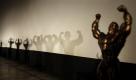 Bodybuilders' shadows are cast on a wall near the trophy during a bodybuilding competition held in the Acapulco cinema in Havana, Saturday, Nov. 7, 2009. Contestants from around the island participated in Cuba's 23rd National Bodybuilding Championship to show their skills. (AP Photo/Javier Galeano)  Foto: ap
