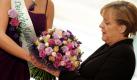 Bundeskanzlerin Angela Merkel (CDU) kann sich in Berlin im Bundeskanzleramt über Blumen freuen, die sie von der Deutschen Blumenfee Christiane Sander überreicht bekommt. Der Strauss zum Valentinstag enthielt die Rosensorten Prärieenzian, blaue Statice und Ranukel.  Foto: dapd