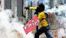 Ein Demonstrant wirft Tränengasbehälter zurück an die Einheiten der Polizei in Quito, Ecuador. Die Demonstranten, darunter viele Schüler, protestierten gegen erhöhte Milchpreise in dem südamerikanischen Land.  Foto: ap