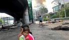 A Thai woman comforts her daughter as fire set by red shirt anti-government protesters burning a building is seen in the background in the red zone area of Din Daeng intersection in central Bangkok, Thailand, 18 May 2010. The ongoing clashes between troops and thousands of red shirt anti-government protesters since 13 May has left 37 dead and injured to 282 including four journalists that has turned the heart of the capital into a war zone. EPA/RUNGROJ YONGRIT +++(c) dpa - Bildfunk+++


Bangkok (dpa) - Der blutige Machtkampf in Bangkok geht an diesem Dienstag in eine neue Runde. Ein Regierungssprecher hat bestätigt, dass Gespräche mit Vertretern der Oppositionellen laufen, aber ein Kompromiss war zunächst nicht in Sicht.

Beide Seiten bestehen darauf, dass die andere den ersten Schritt tut: Die Demonstranten verlangen zuerst einen Abzug der Soldaten, die Regierung verlangt zuerst ein Ende der Proteste.

UN-Generalsekretär Ban Ki Moon hat am Montagabend erneut beide Seiten zur Zurückhaltung aufgerufen. Die Vereinten Nationen seien zur Vermittlung bereit, könnten aber nur auf Bitten der Regierung aktiv werden. Das hat die Regierung bislang kategorisch abgelehnt. Thailand könne seine Probleme selbst lösen, sagte ein Regierungssprecher.

Bei den jüngsten Kämpfen zwischen Soldaten und Regierungsgegnern kamen in fünf Tagen mindestens 36 Menschen ums Leben. Die Regierungsgegner haben sich in einem Geschäftsviertel verbarrikadiert und sind mit Benzinbomben und Wurfgeschossen bewaffnet. Die Armee hat das Gelände weitgehend umzingelt und schießt auf Demonstranten, die versuchen, neue Barrikaden aufzubauen. Foto: dpa
