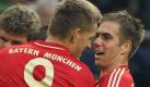Bayern-Kapitän Philipp Lahm (r) gratuliert Nils Petersen, dem Schützen zum 1:0 auf Schalke. Foto: dpa