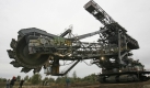 Der Schaufelradbagger SRs 1300 fährt im Braunkohletagebau bei Profen. Der 1750 Tonnen schwere, 30 Meter hohe und 80 Meter lange Bagger überwindet zwischen zwei Abbaufeldern eine etwa sechs Kilometer lange Strecke.
 Foto: ddp
