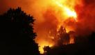 Residenten schauen am Rande eines Waldes in der Nähe von  Fornelos de Montes in Galizien den mächtigen Feuerschwaden zu. Zwei Feuerwehrmänner starben als sie versuchten, die Flammen zu bekämpfen. Foto: dpa