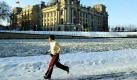 Eine Joggerin läuft am Ufer der vereisten Spree in Berlin-Mitte entlang. ImHintergrund ist das Reichtstagsgebäude zu sehen.  Foto: ddp