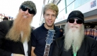 Die Mitglieder von ZZ Top, Dusty Hill (rechts) und Billy Gibbons posieren mit dem deutschen Formel Eins-Fahrer Sebastian Vettel von Red Bull Racing im Fahrerlager von Marina Bay Street Circuit in Singapur. Foto: dpa